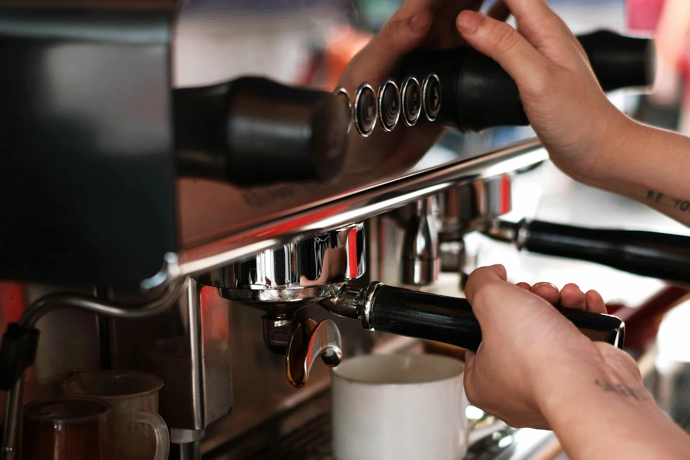 a close up of a barista making a cup of coffee